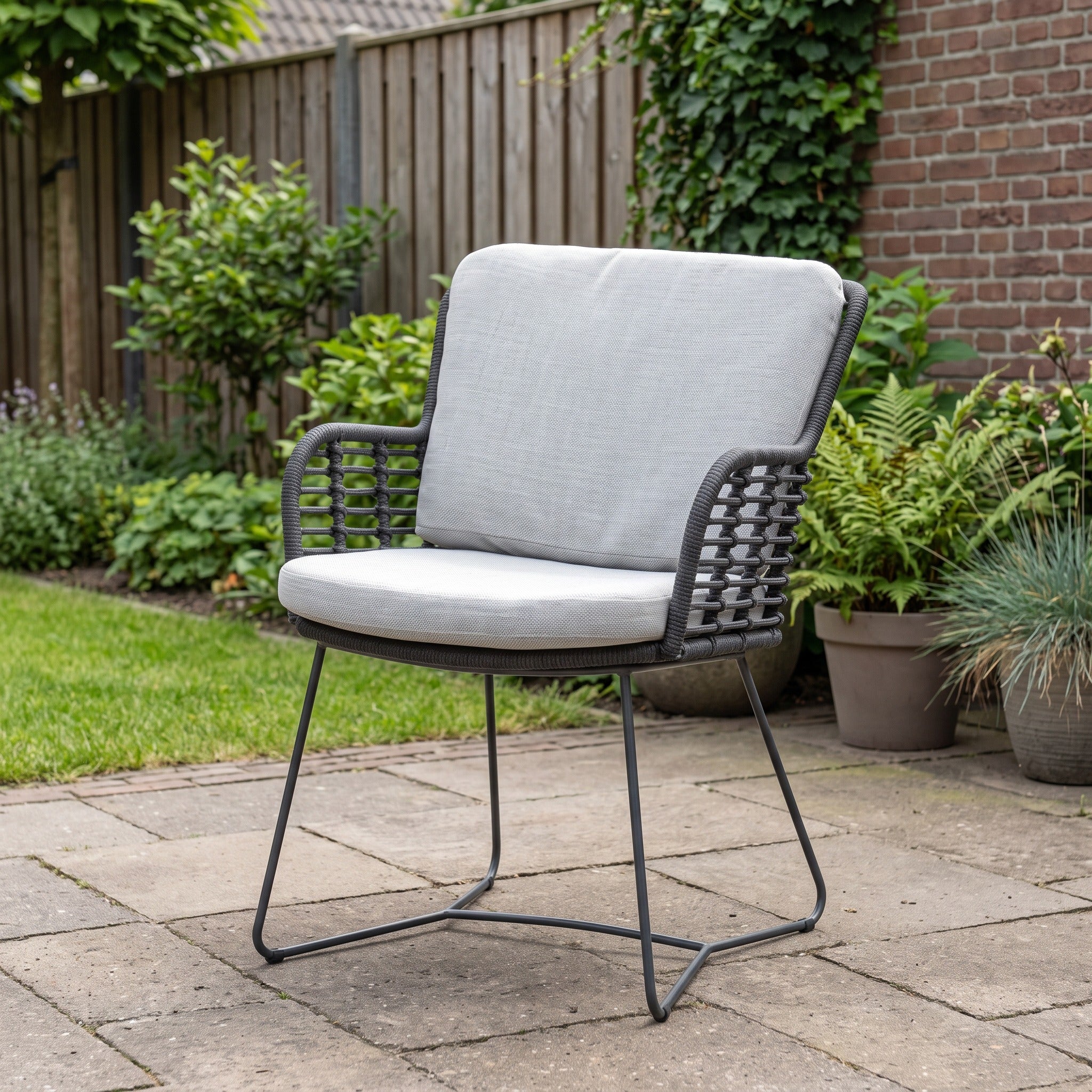 4 Seasons Outdoor Fabrice dining stoel antraciet incl. 2 kussens in een Nederlandse tuinomgeving