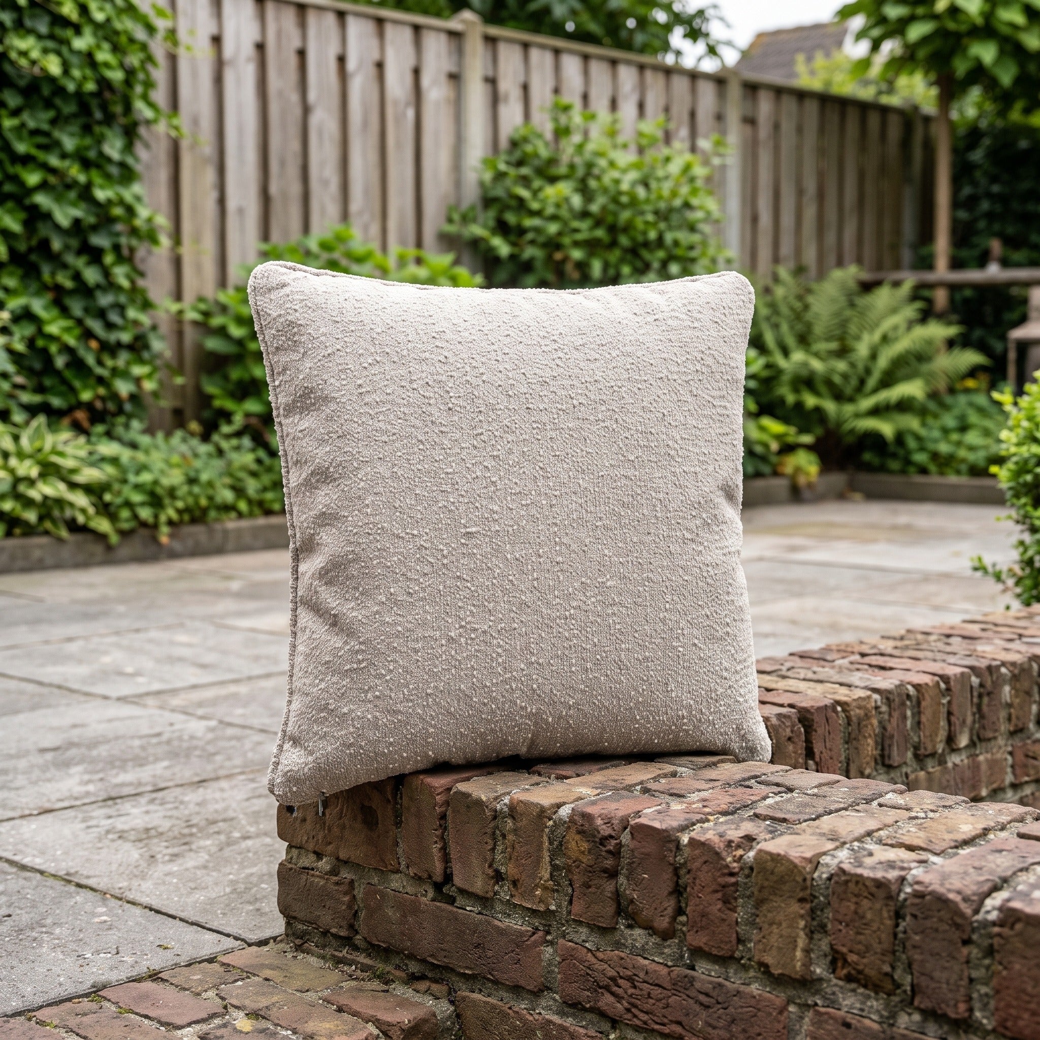 4 Seasons Outdoor sierkussen 50 x 50 cm Bouclé Clay in een Nederlandse tuinomgeving