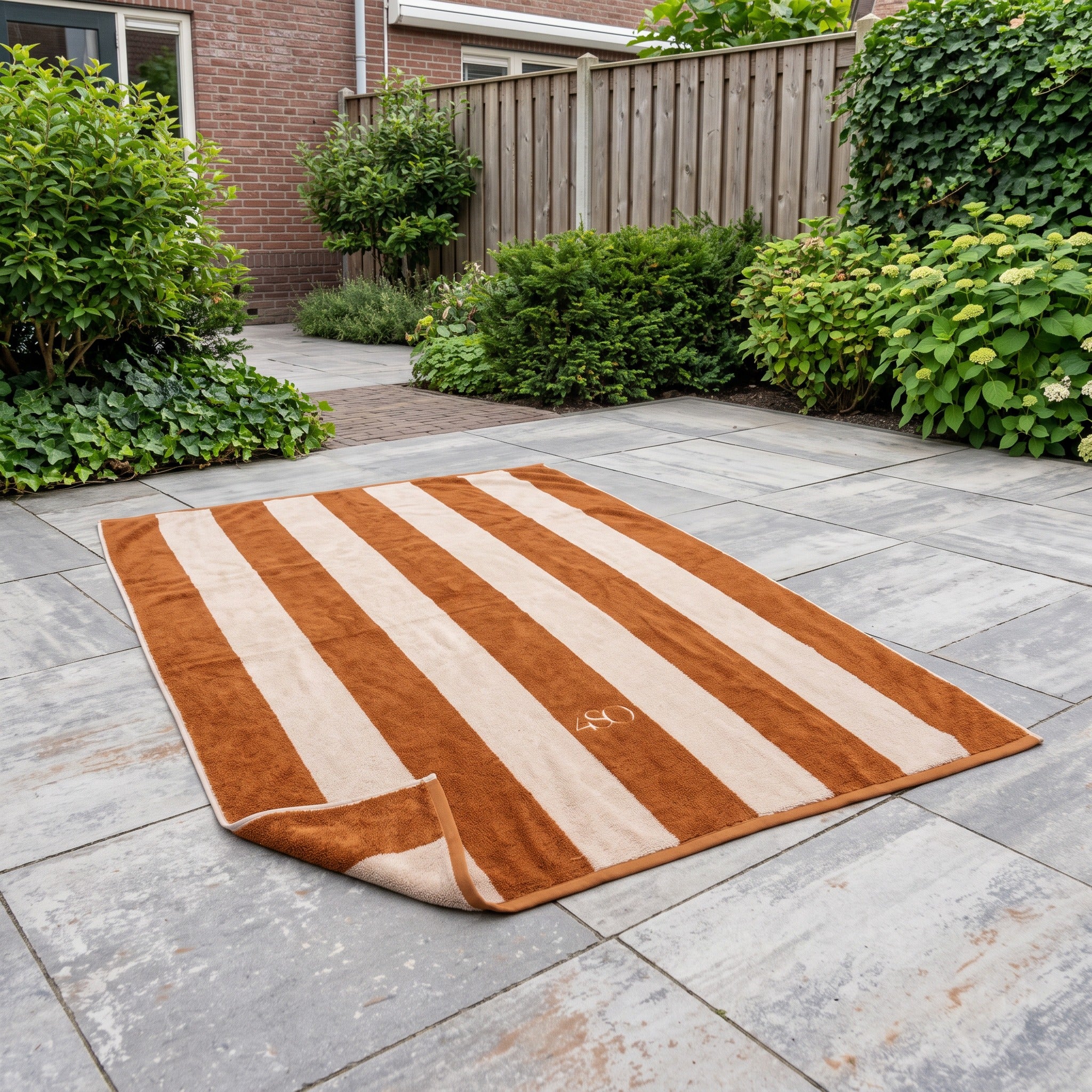 4 Seasons Outdoor Handdoek 180 x 100 cm caramel / zand in een Nederlandse tuinomgeving