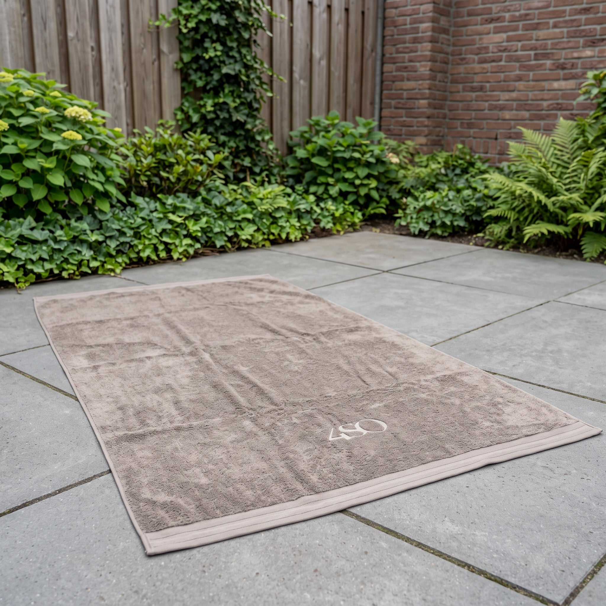 4 Seasons Outdoor Handdoek 180 x 100 cm taupe in een Nederlandse tuinomgeving
