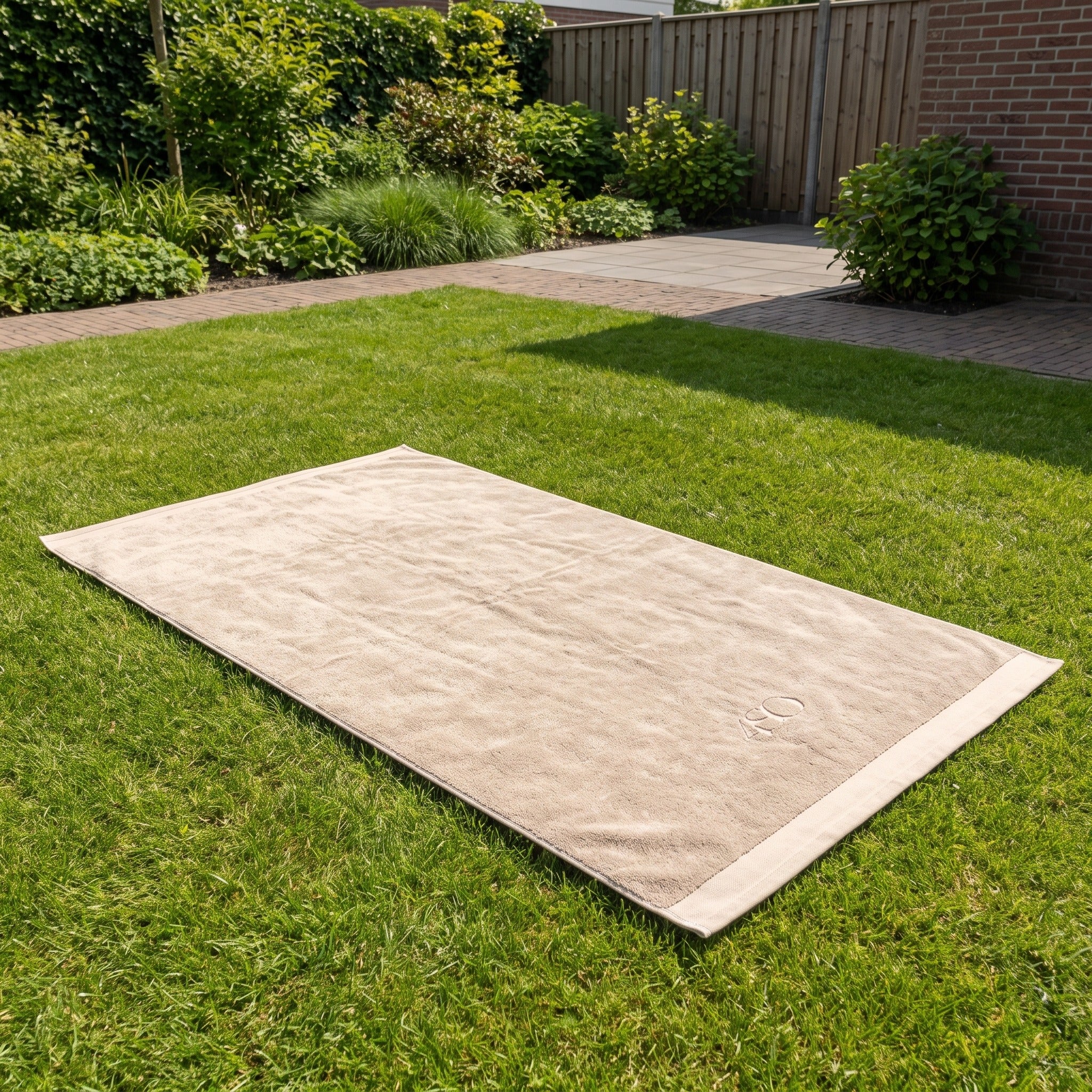 4 Seasons Outdoor Handdoek 180 x 100 cm zand in een Nederlandse tuinomgeving