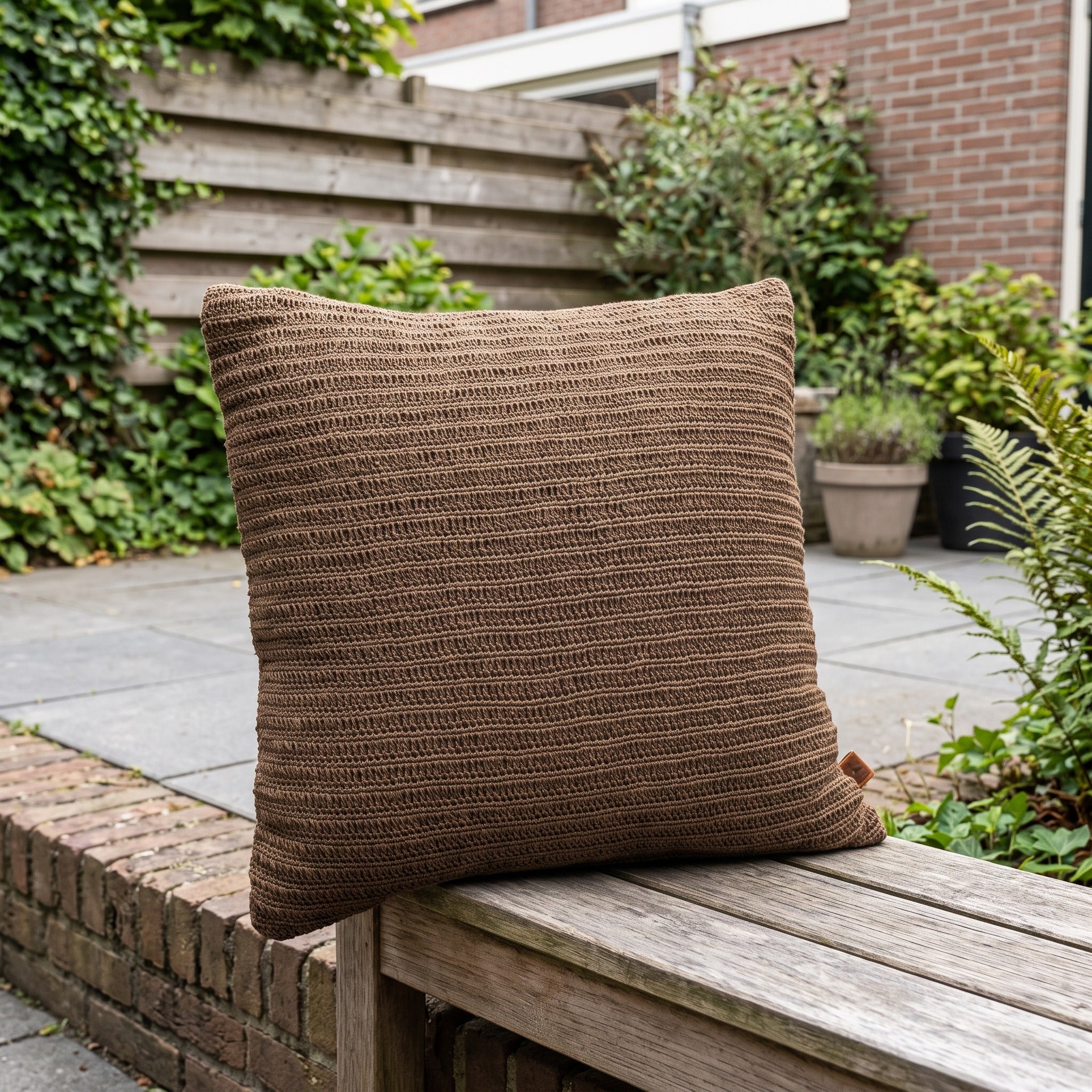 4 Seasons Outdoor sierkussen gehaakt, 50 x 50 cm coffee in een Nederlandse tuinomgeving