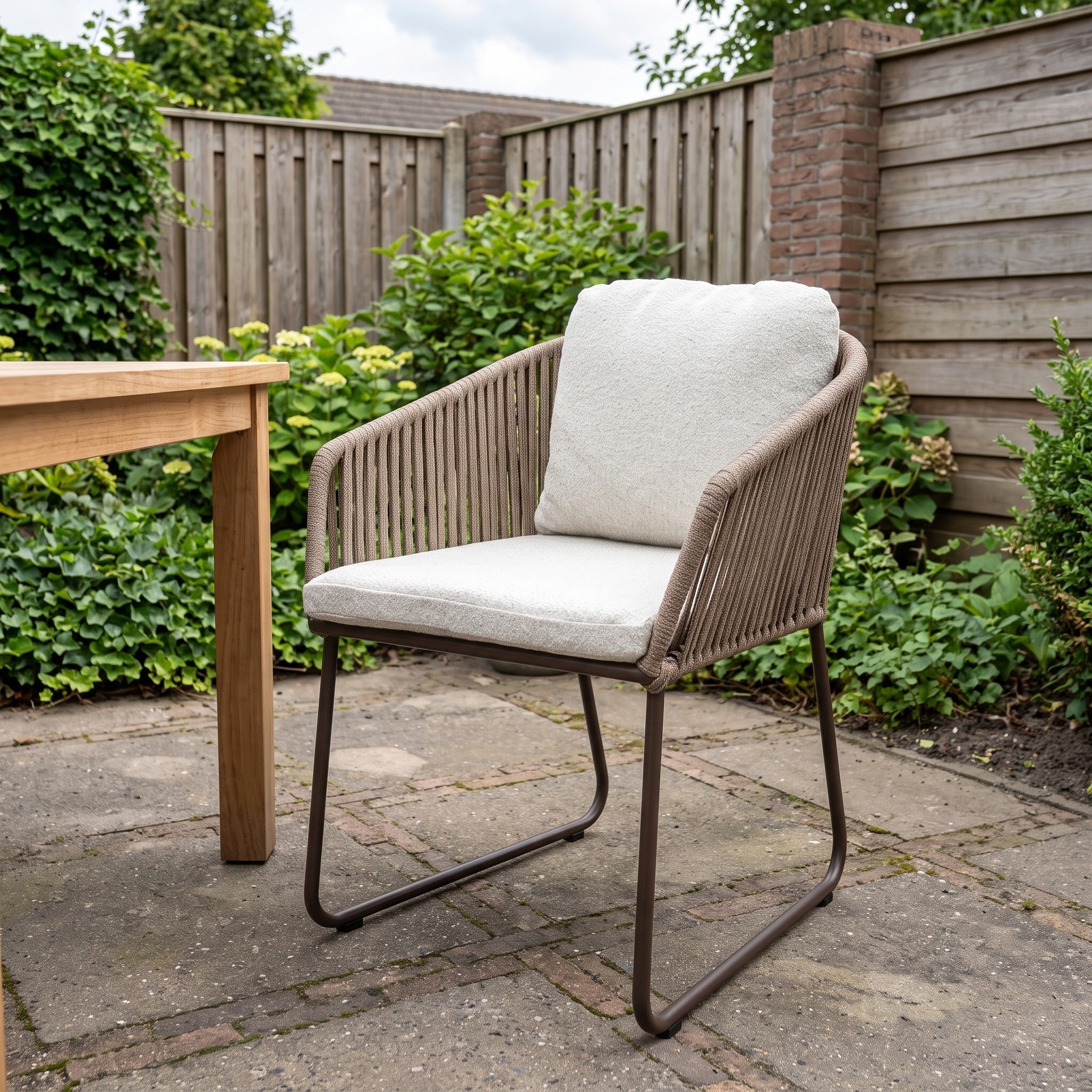 Yoi Calera low dining stoel alu bronze/belt toffee/wool white AW in een Nederlandse tuinomgeving
