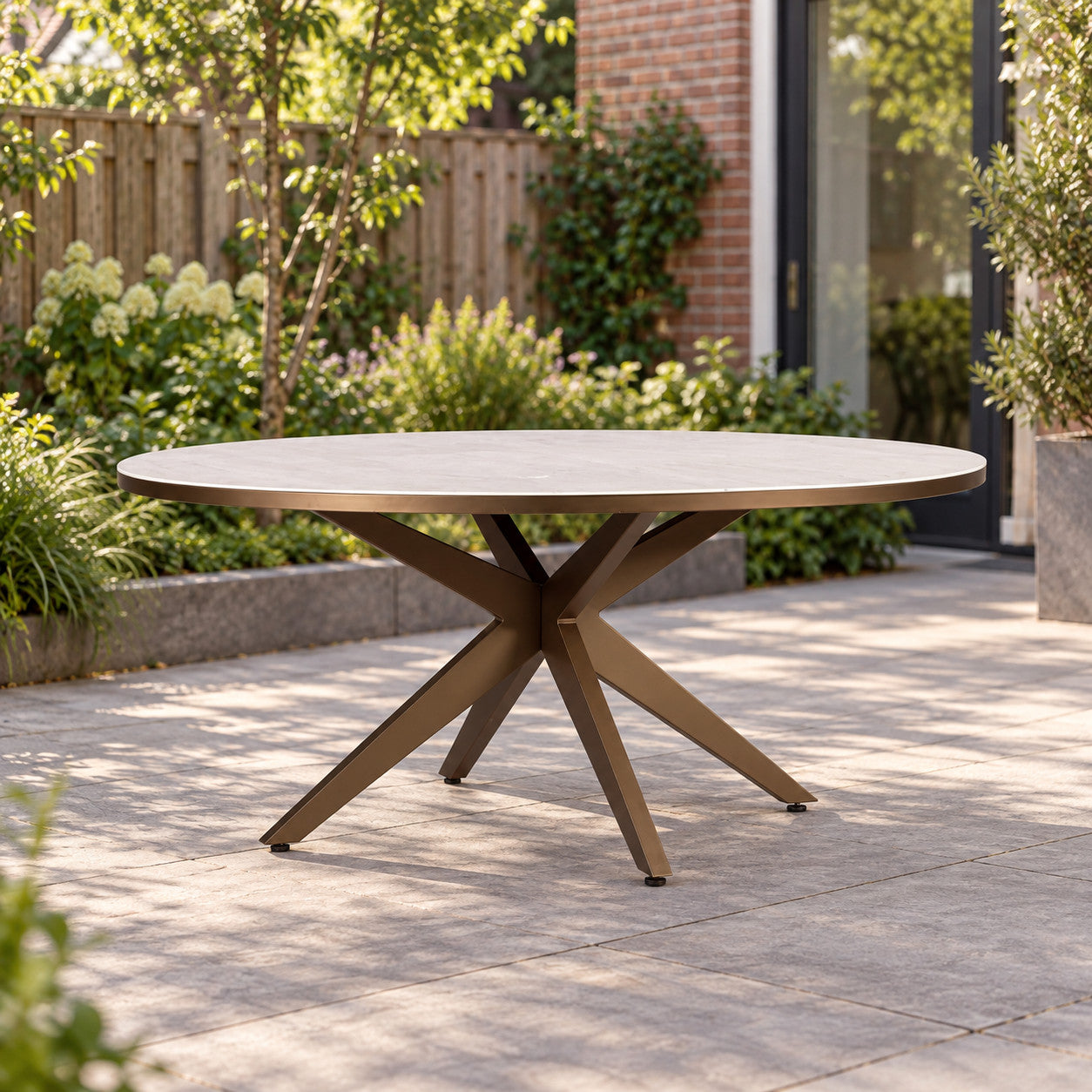 Yoi Calma low dining tafel Ø160cm alu bronze/travertin in een Nederlandse tuinomgeving
