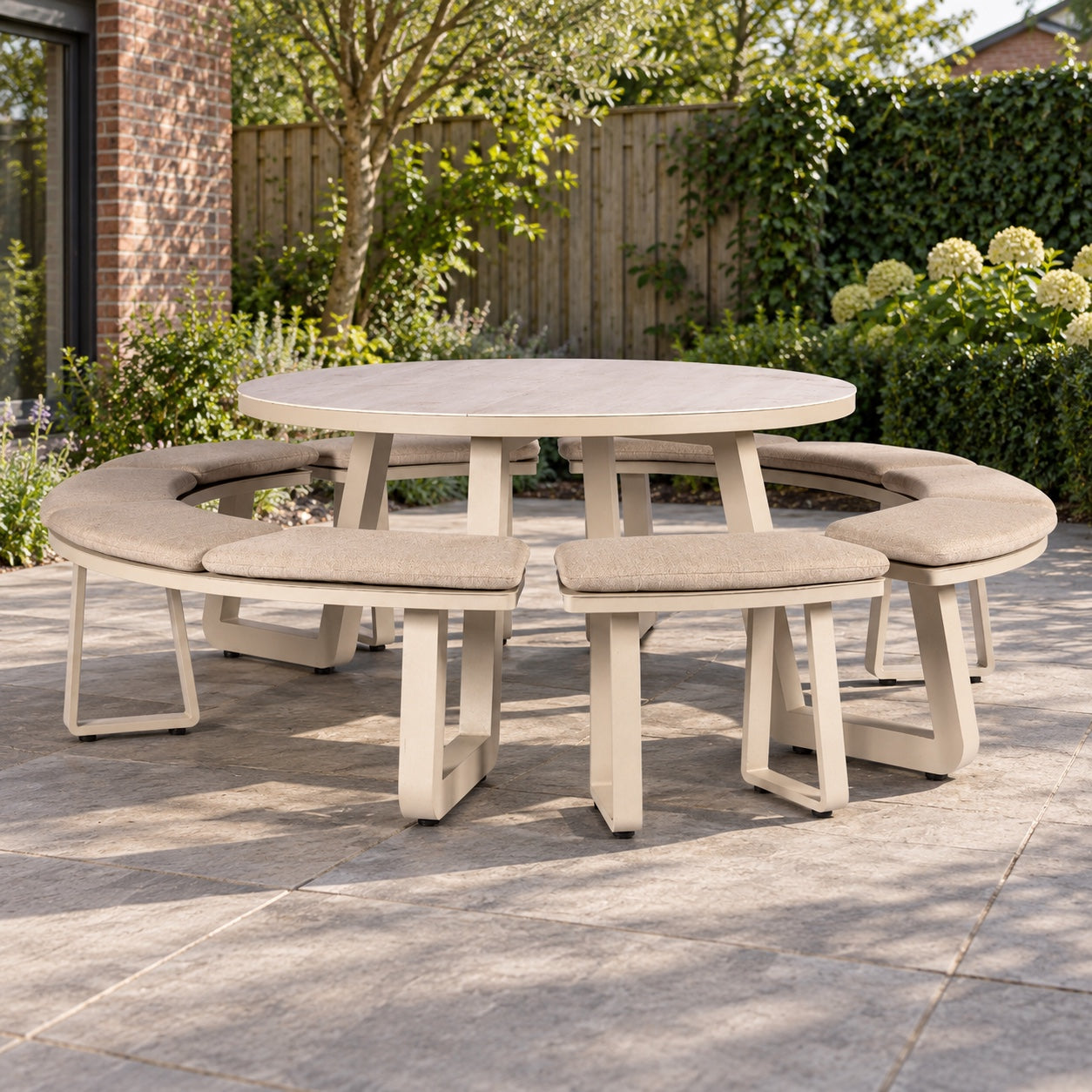 Yoi Comporta picknicktafel Ø150cm alu salix/travertin/flax beige AW in een Nederlandse tuinomgeving