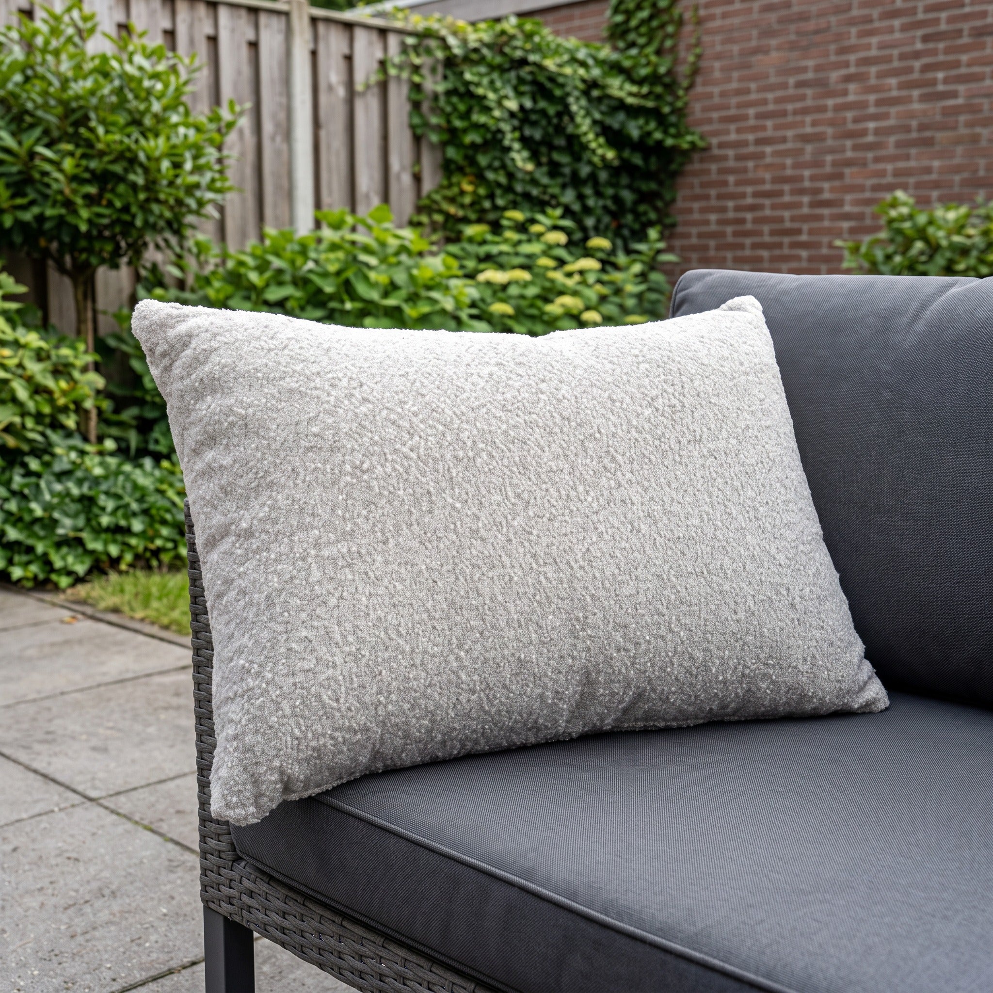 Yoi sierkussen 70x50 wool white in een Nederlandse tuinomgeving