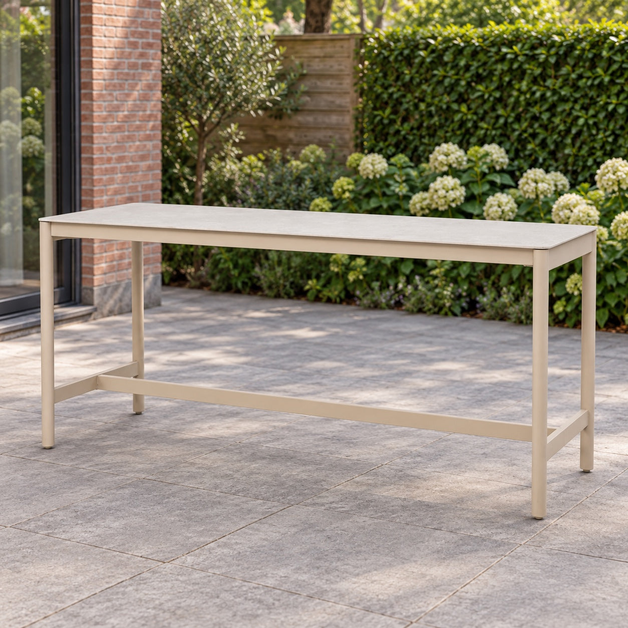 Taste by 4SO Soho hoge tuintafel in latte met keramisch blad in een Nederlandse achtertuin.