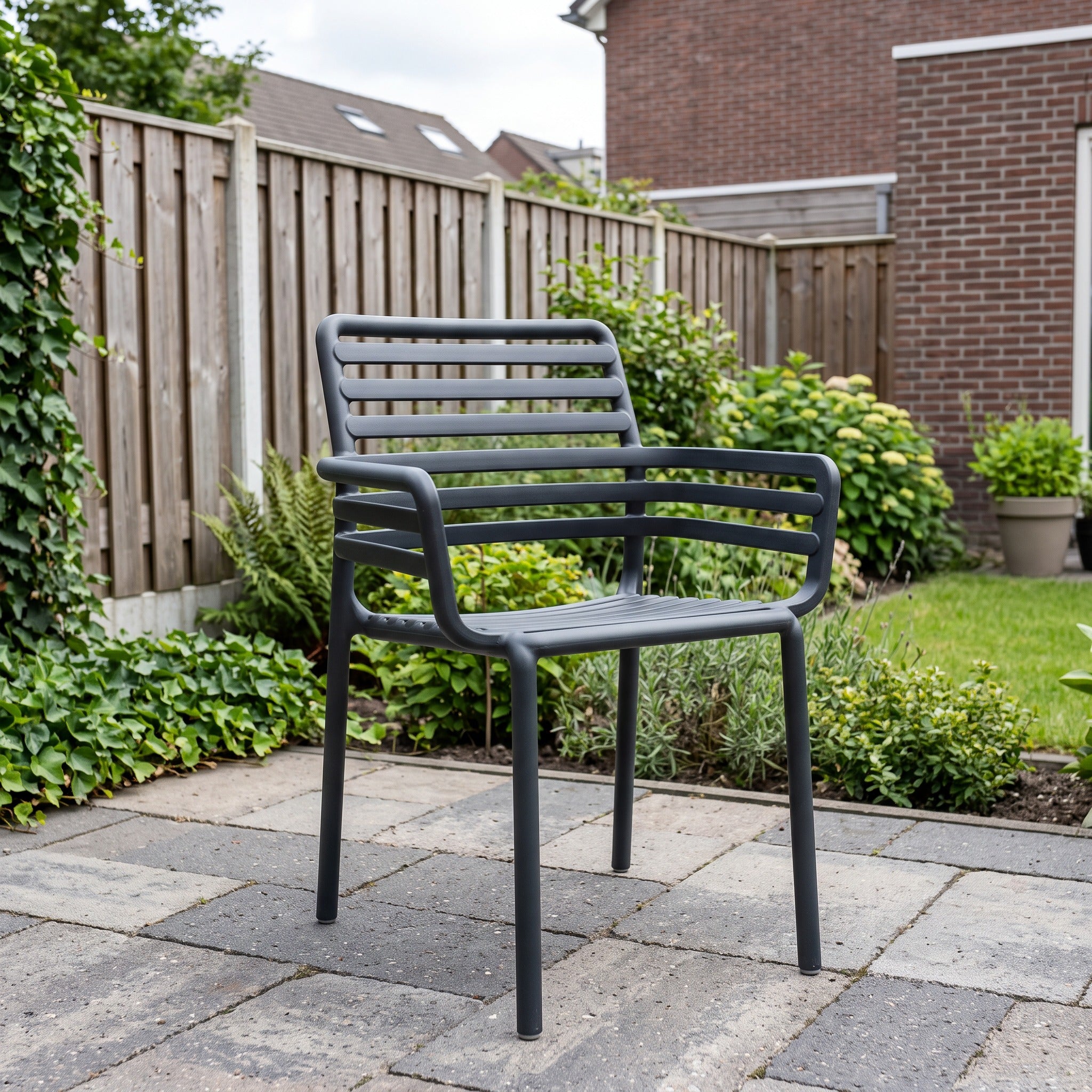 Nardi Doga Armstoel antraciet in een Nederlandse tuinomgeving