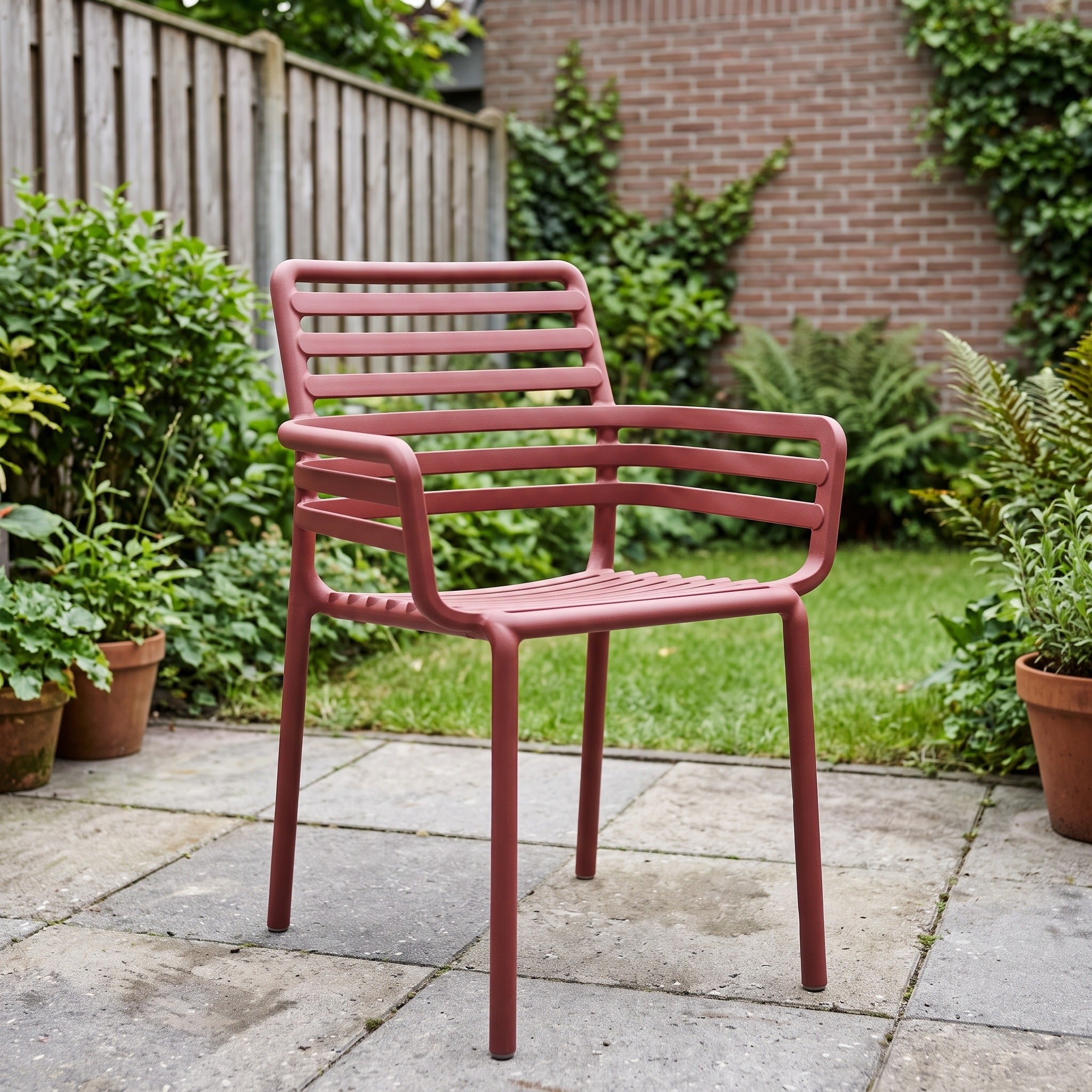 Nardi Doga Armstoel marsala in een Nederlandse tuinomgeving