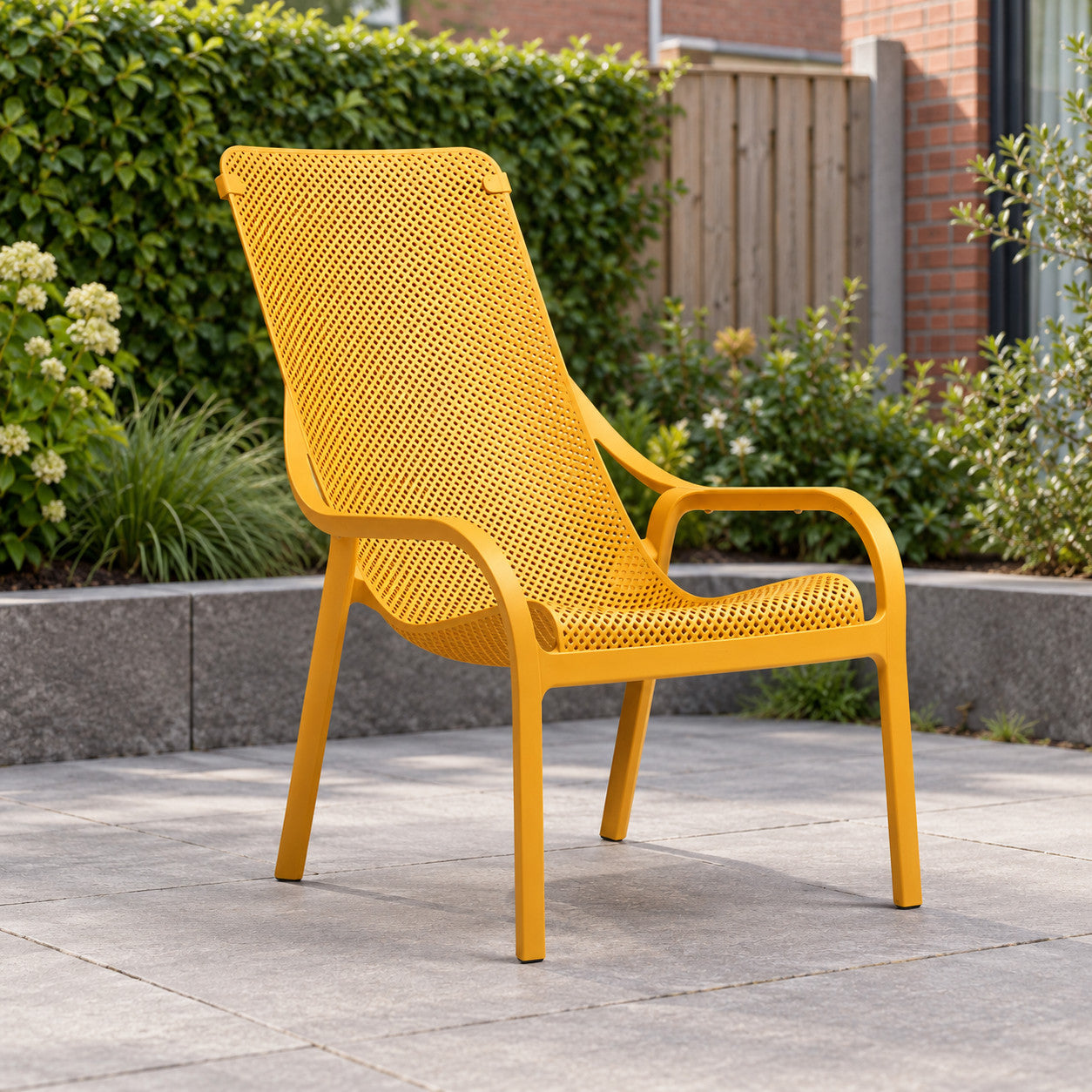 Nardi Net Lounge stoel senape in een Nederlandse tuinomgeving
