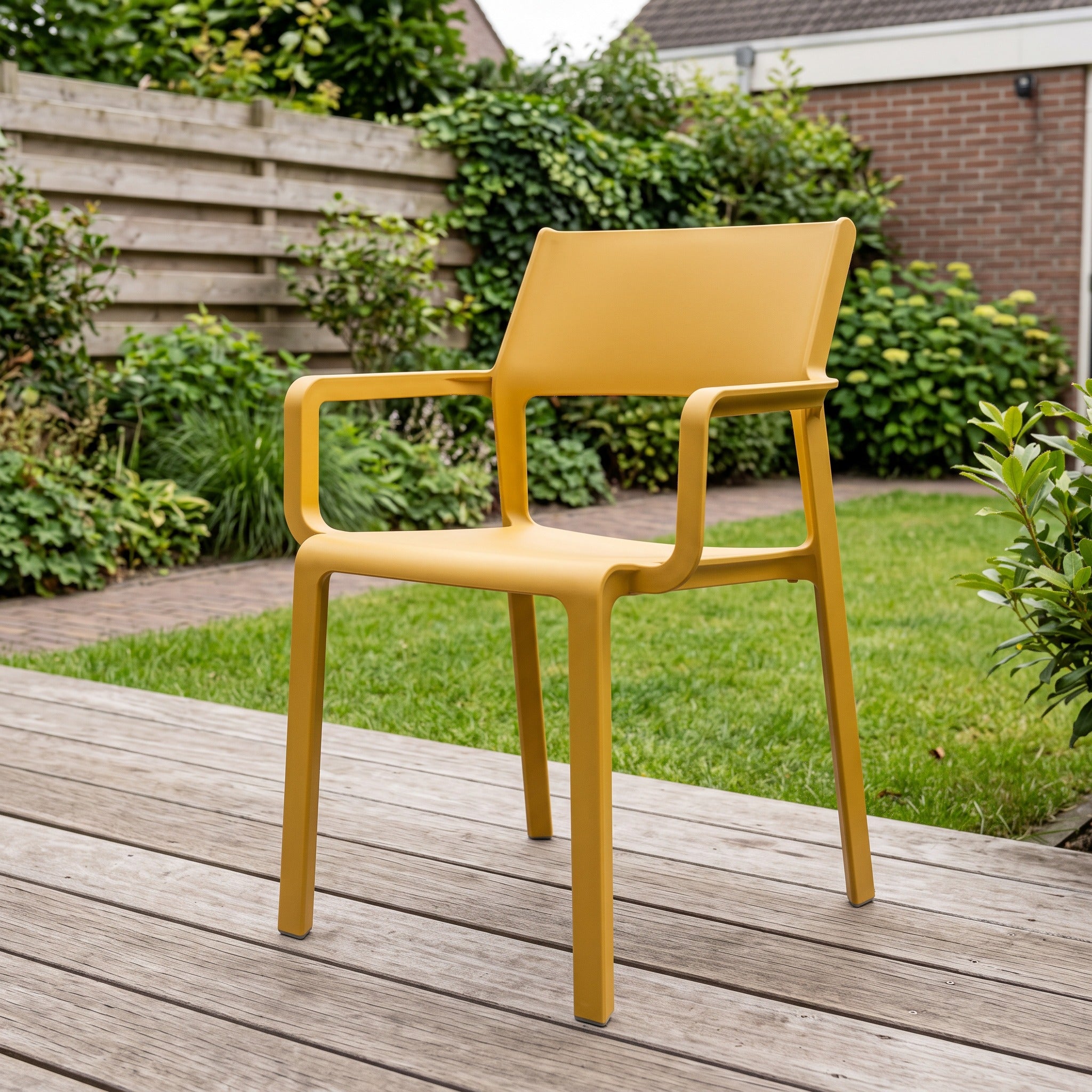 Nardi Trill Tuinstoel senape in een Nederlandse tuinomgeving