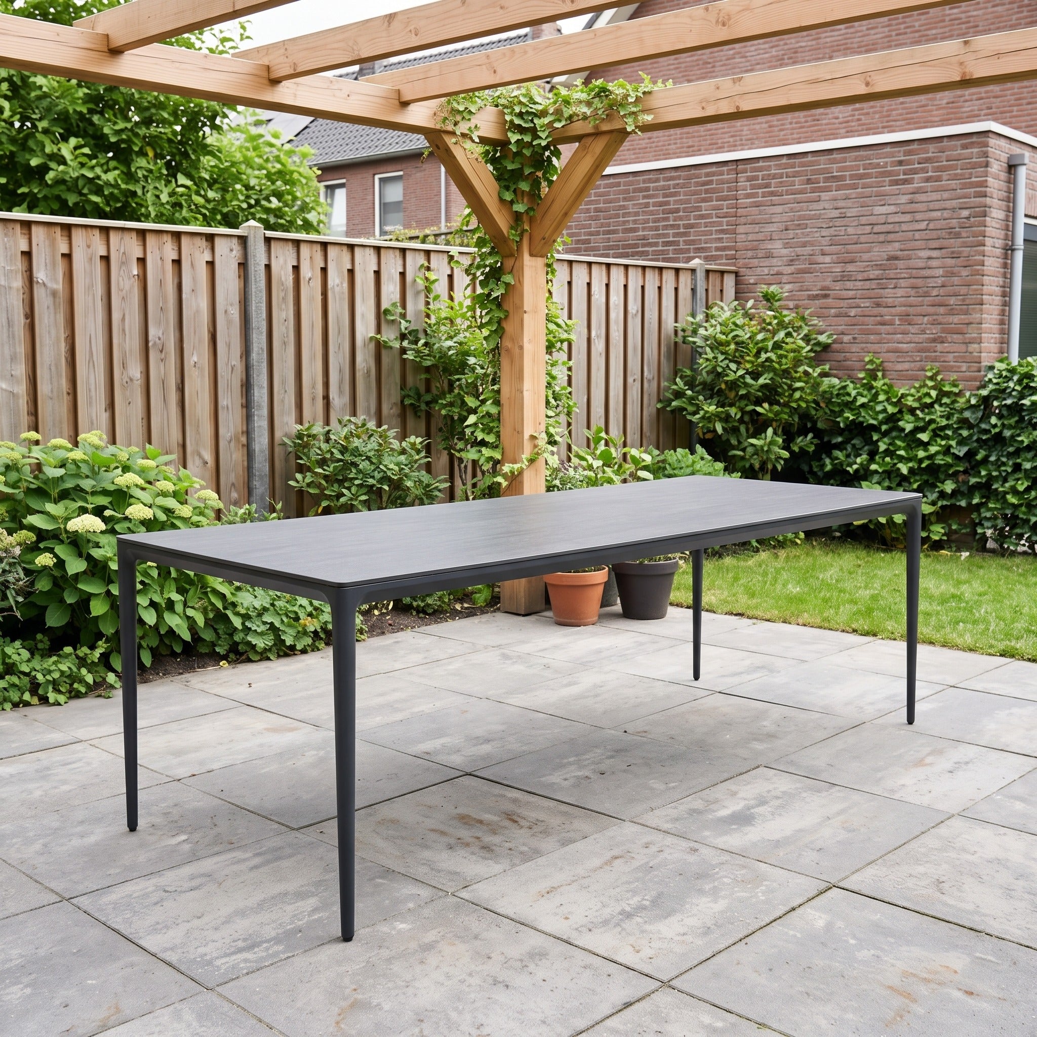 Tierra Outdoor Elegante eettafel Charcoal Trespa Forest Grey 219 x 92 cm in een Nederlandse tuinomgeving