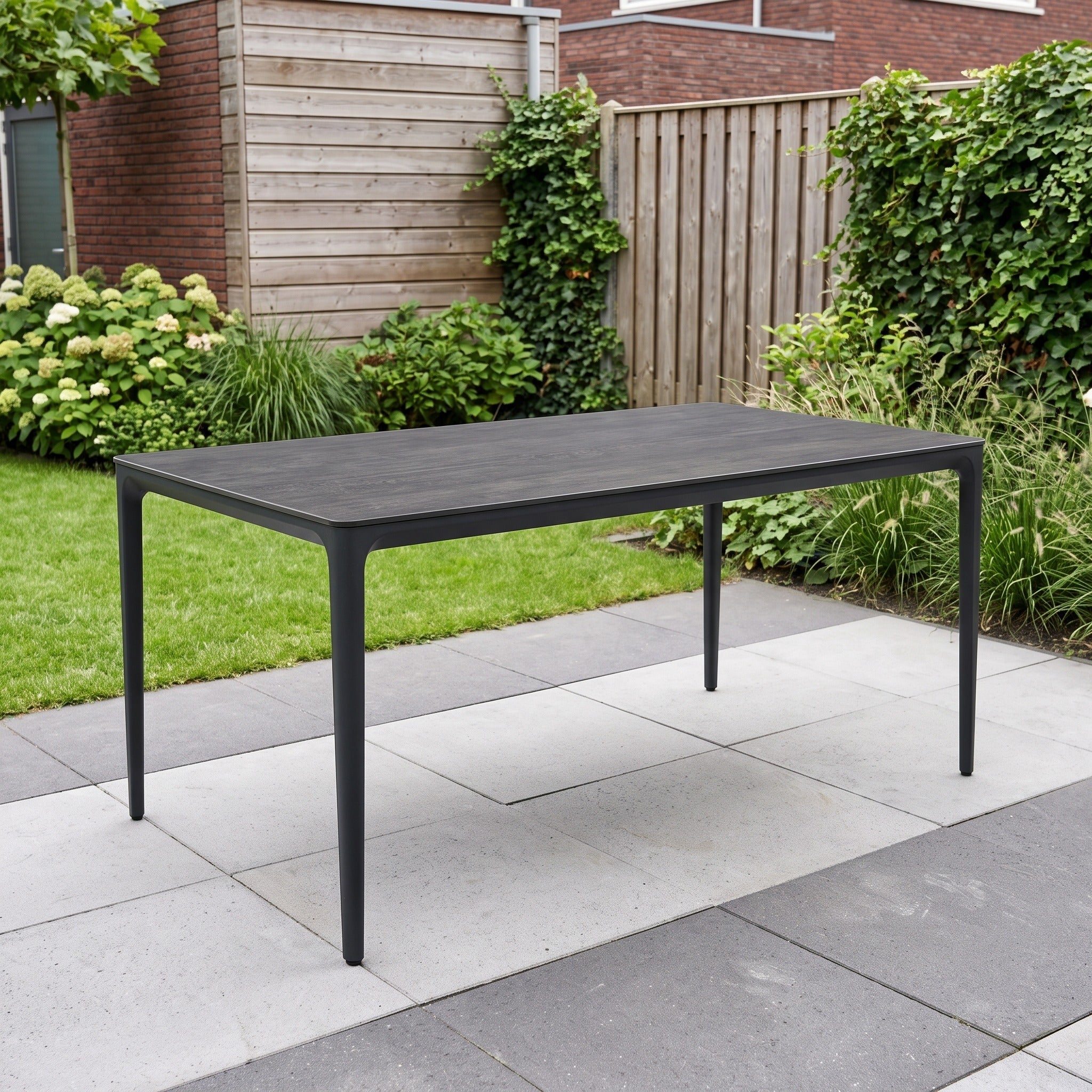 Tierra Outdoor Elegante eettafel Charcoal Trespa Forest Grey 160 x 92 cm in een Nederlandse tuinomgeving
