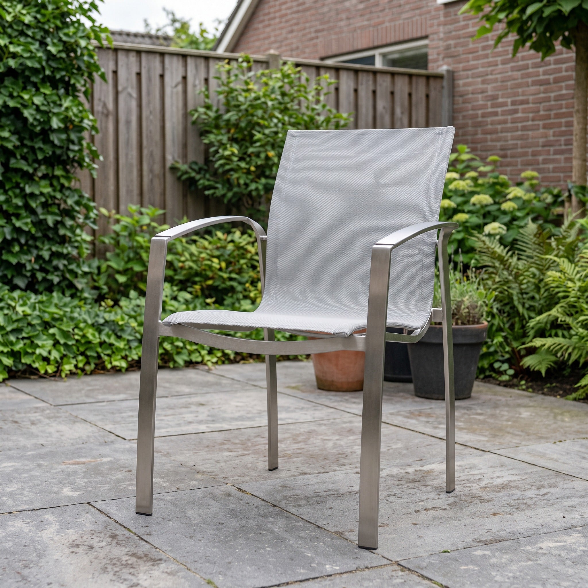 4 Seasons Outdoor Summit RVS dining stoel Ash Grey Tex in een Nederlandse tuinomgeving