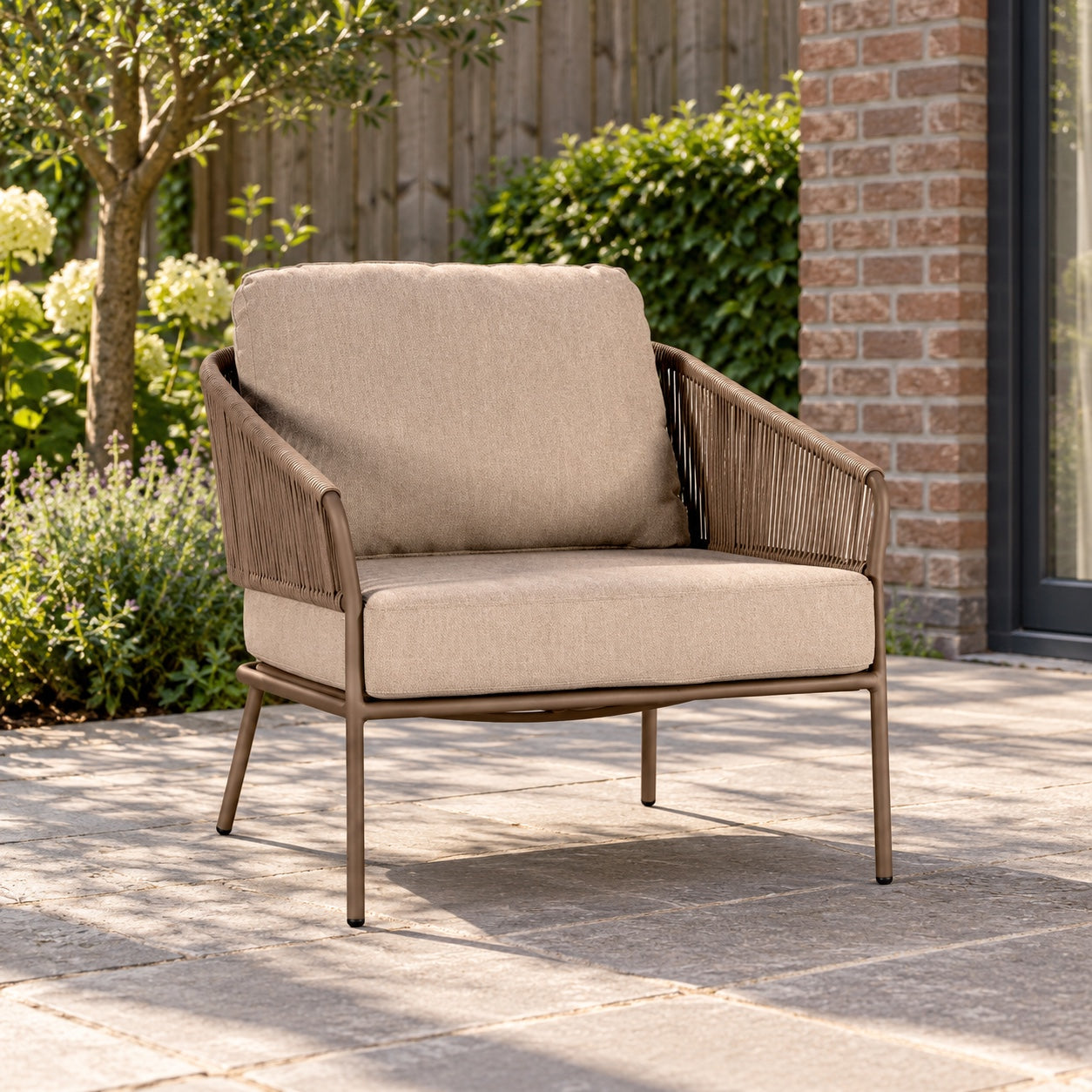 Yoi Forio loungestoel alu bronze/rope toffee/flax beige AW in een Nederlandse tuinomgeving