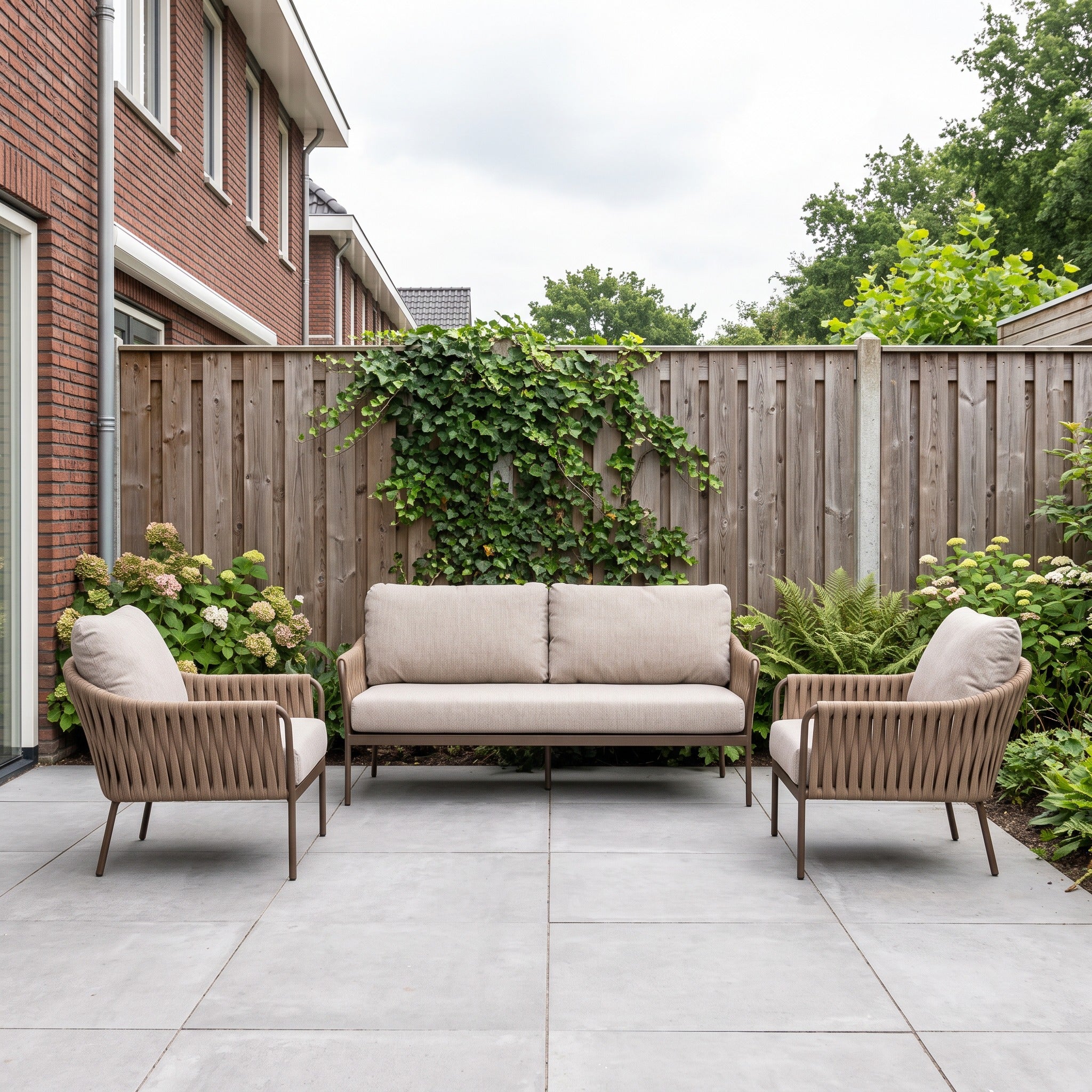 Yoi Hydra loungeset: 3-zitsbank + 2 Hydra loungestoelen in een Nederlandse tuinomgeving